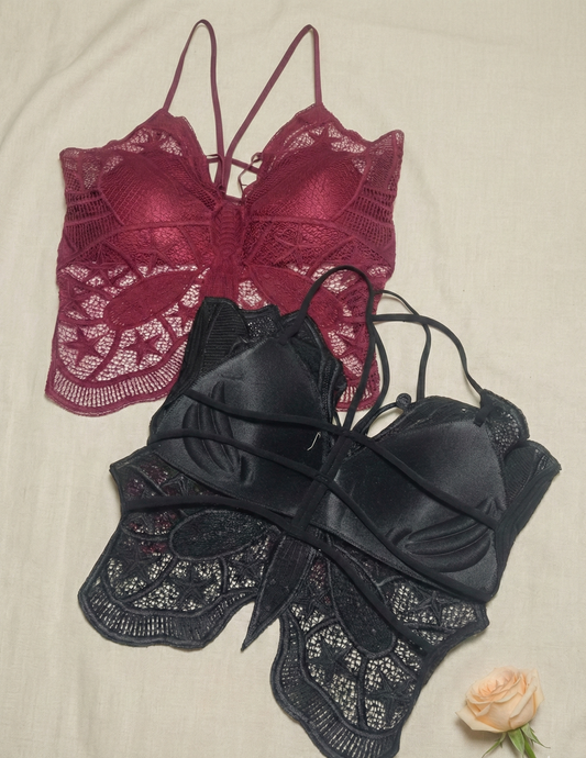 Red and black lace bras on a beige background with a rose.